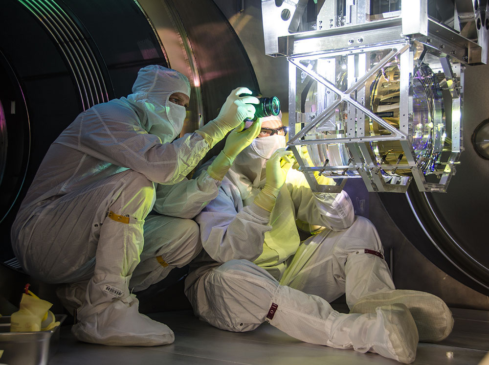 A couple of scientists looking at a space telescope
