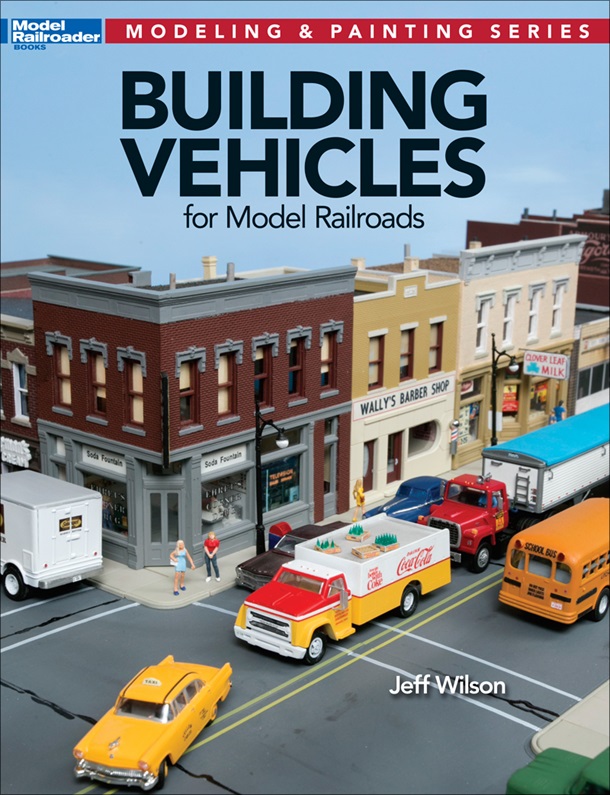 Building vehicles for your model railroad cover shows a section of a layout with model buildings and traffic