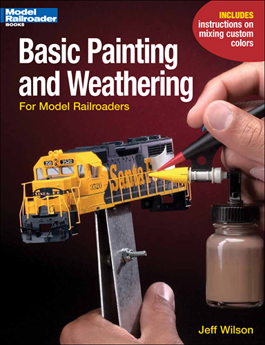 the cover shows a close up of a hand holding a brush that's painting a diesel locomotive ho scale model