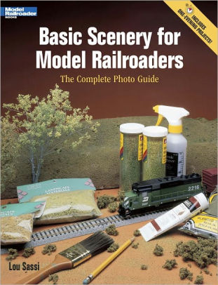 The cover shows a layout work in progress with various tools and supplies for scenery
