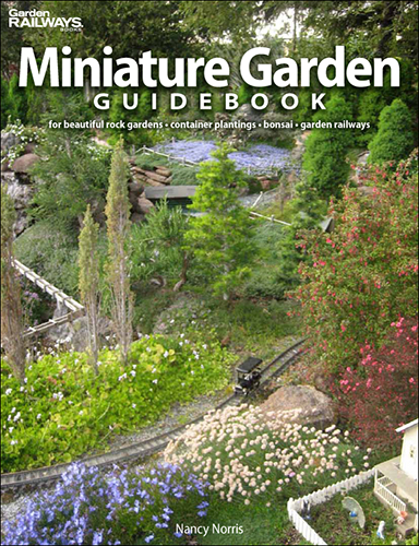 the cover shows a small garden with a train layout