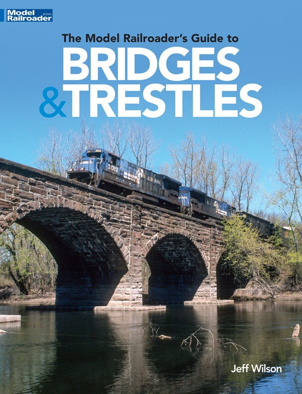 the cover shows a freight train crossing a bridge over a river
